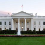 The White House with fountain and American flag.