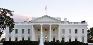 The White House with fountain and American flag.