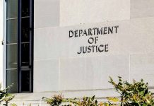 Department of Justice building exterior with window and plants.