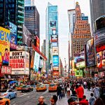 Times Square crowded with people and bright electronic advertisements.