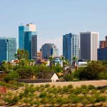 City skyline with tall buildings and greenery.