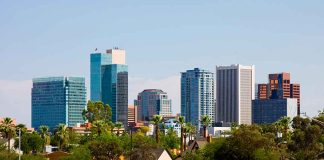 City skyline with tall buildings and greenery.