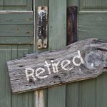 Wooden "Retired" sign on an old green door.