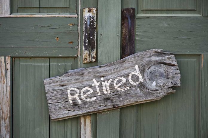 Wooden "Retired" sign on an old green door.