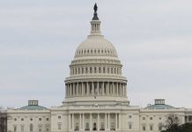 United States Capitol building under cloudy sky.