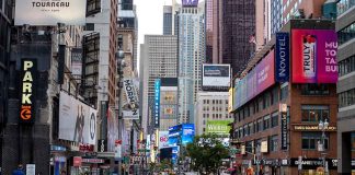 Times Square street scene with storefronts and advertisements.