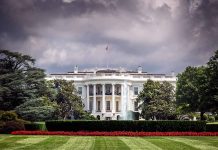 White House front view with dark clouds above.