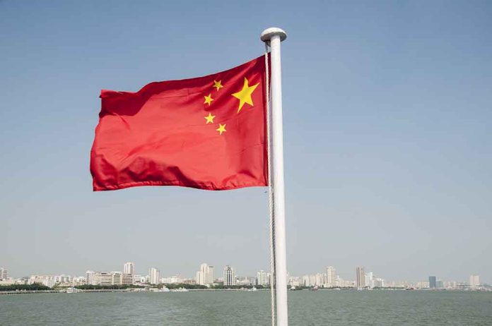 Chinese flag waving over cityscape and water.