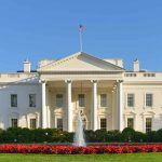 White House with fountain and flowers in foreground.