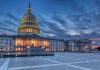 Capitol building illuminated against evening sky.