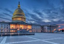 Capitol building illuminated against evening sky.