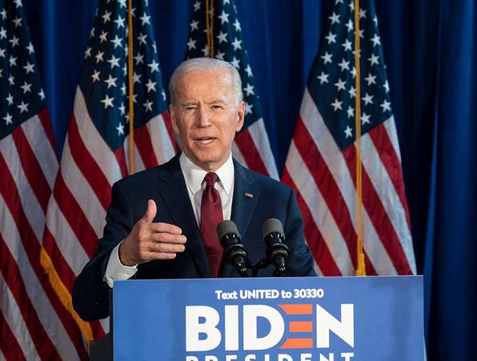 Man speaking at podium with American flags behind.