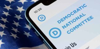 Phone displaying Democratic National Committee website over flag.