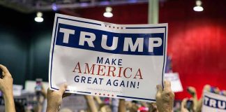 Sign at crowded rally for Trump campaign.