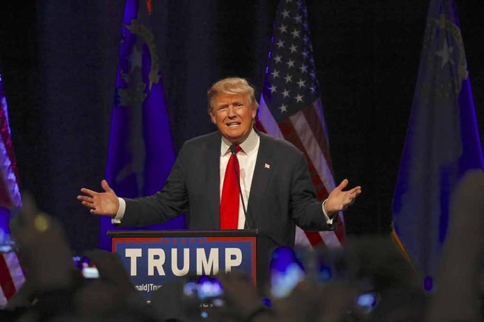 Man speaking at podium with flags behind him.