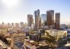 City skyline with tall buildings under a sunny sky.