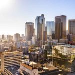 City skyline with tall buildings under a sunny sky.