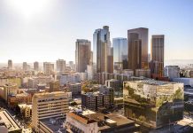 City skyline with tall buildings under a sunny sky.