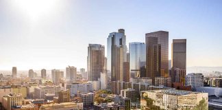 City skyline with tall buildings under a sunny sky.