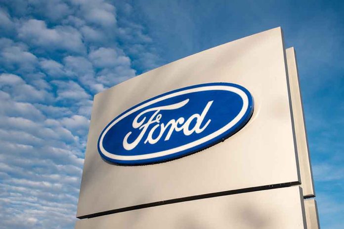 Ford logo sign against blue sky.