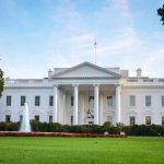 White house with fountain and flags, front view.