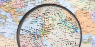 Magnifying glass over Middle East map highlighting Israel and Egypt.