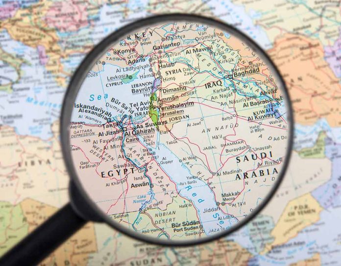 Magnifying glass over Middle East map highlighting Israel and Egypt.