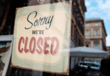 "Sorry, we're closed" sign on a window.