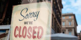 "Sorry, we're closed" sign on a window.