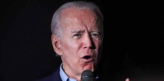 Man speaking into microphone in a dark setting