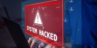 Warning sign "System Hacked" on laptop screen.