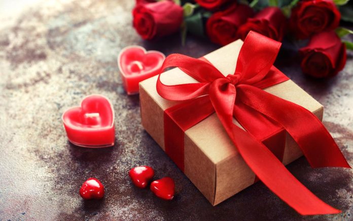 Gift box with red ribbon and heart candles