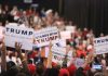 Crowd holding signs supporting Trump at rally.