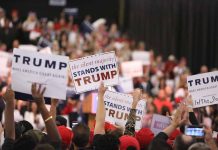 Crowd holding signs supporting Trump at rally.