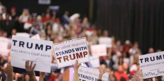 Crowd holding signs supporting Trump at rally.