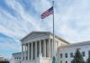 Supreme Court building with American flag flying.