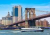 Boat passing under Brooklyn Bridge in New York.