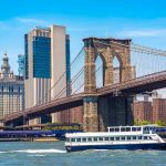 Boat passing under Brooklyn Bridge in New York.