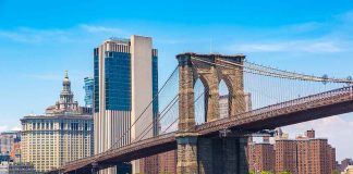 Boat passing under Brooklyn Bridge in New York.