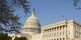 United States Capitol building with surrounding trees.