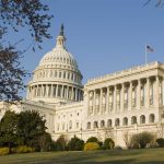 United States Capitol building with surrounding trees.