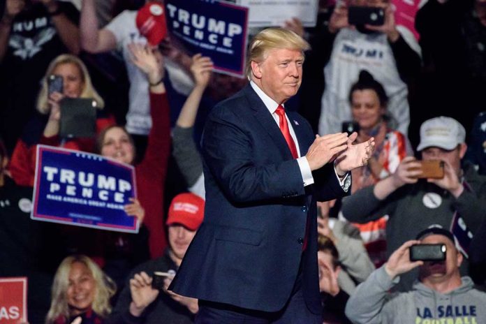 Man clapping at a rally with audience cheering.