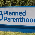 Planned Parenthood sign on a grassy lawn.