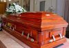 Wooden casket with white flowers in a funeral home.