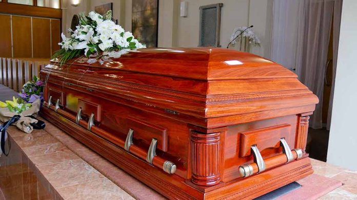 Wooden casket with white flowers in a funeral home.