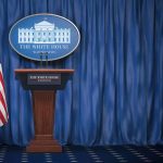 Empty White House podium and American flag.