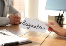 Person handing over resignation letter at a desk.