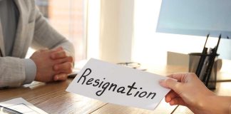 Person handing over resignation letter at a desk.