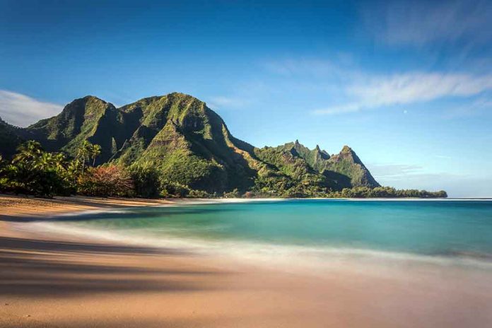 Beach with mountains and clear blue water.