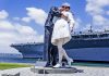 Statue of a sailor kissing a nurse, waterside backdrop.